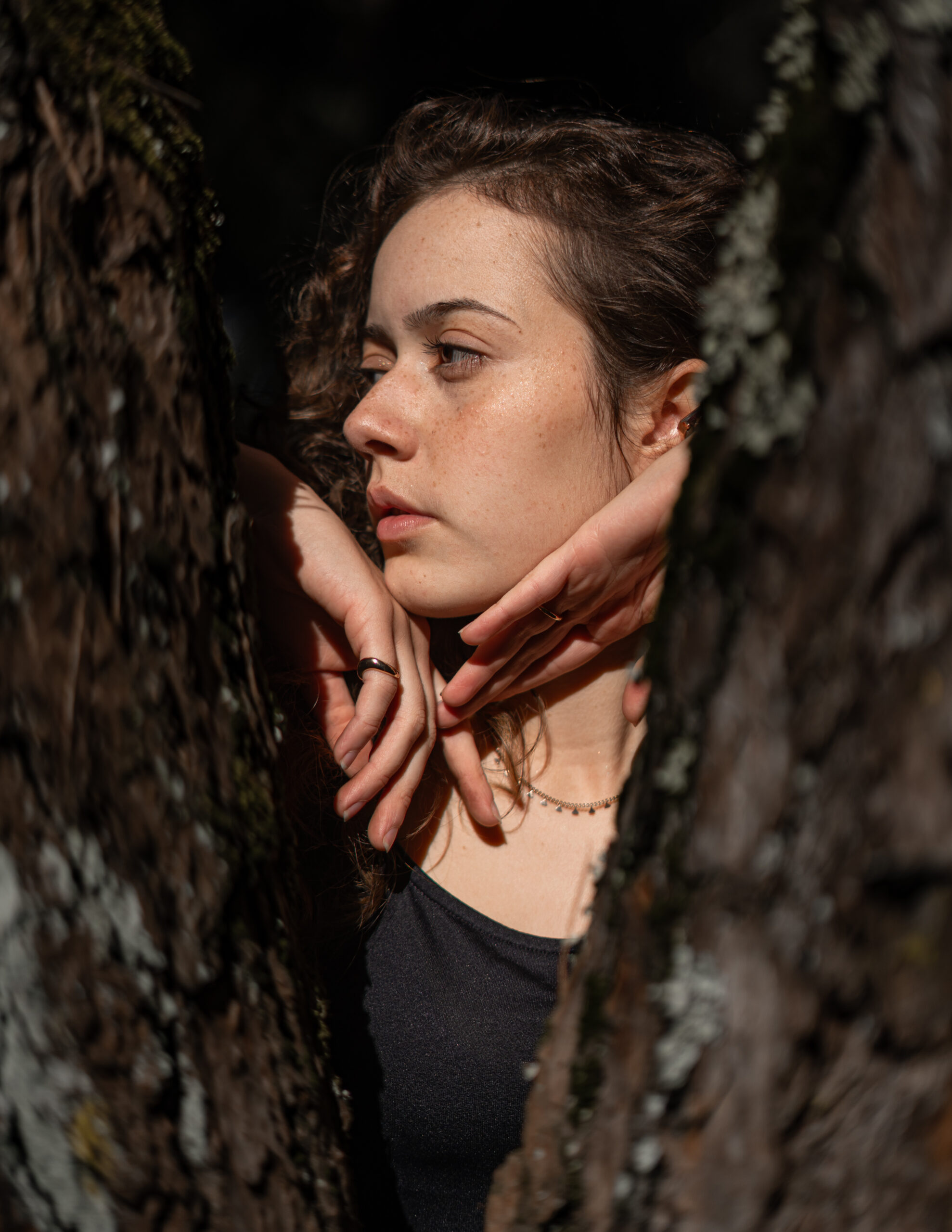 Girl looking sideways in middle of trees