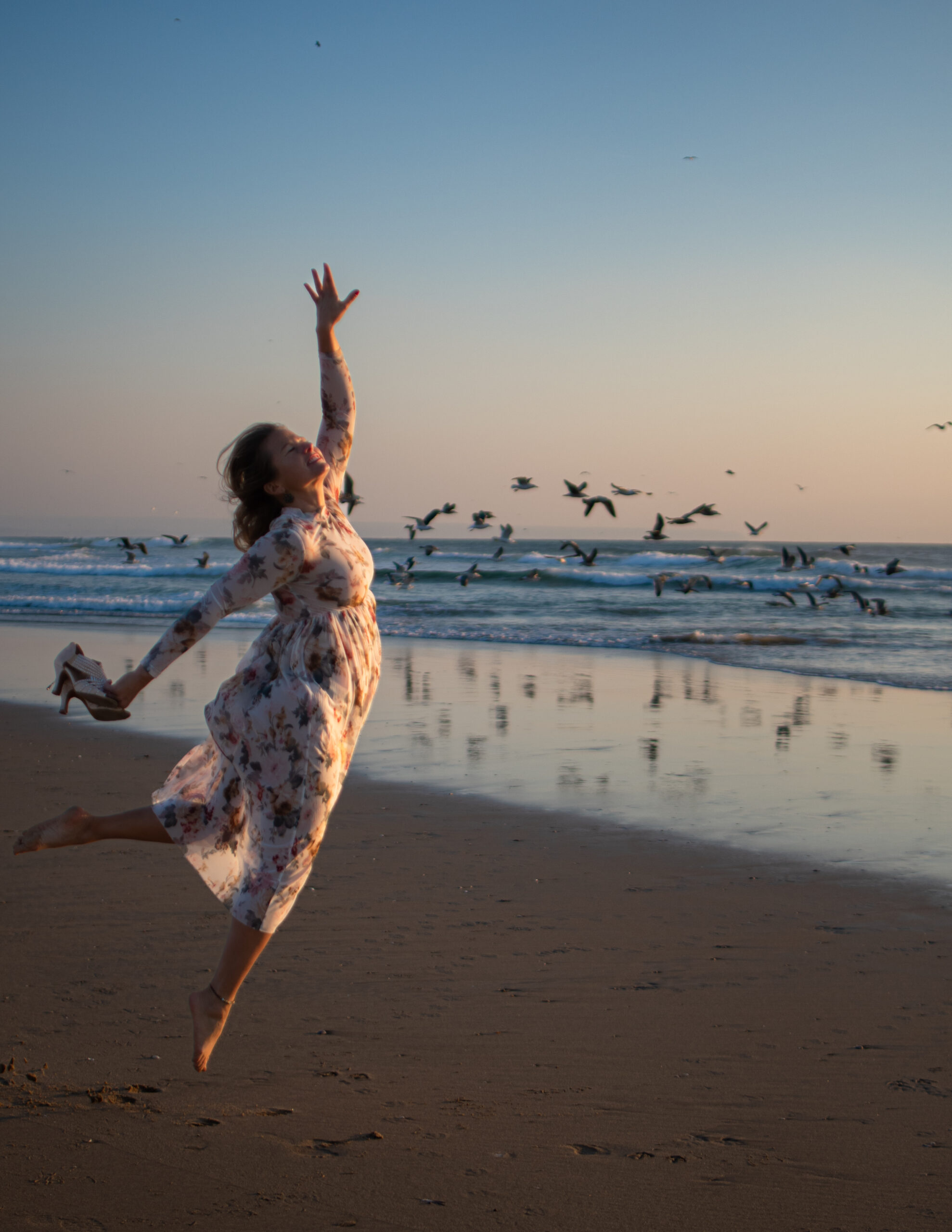 Dancer flying with bird at the beach