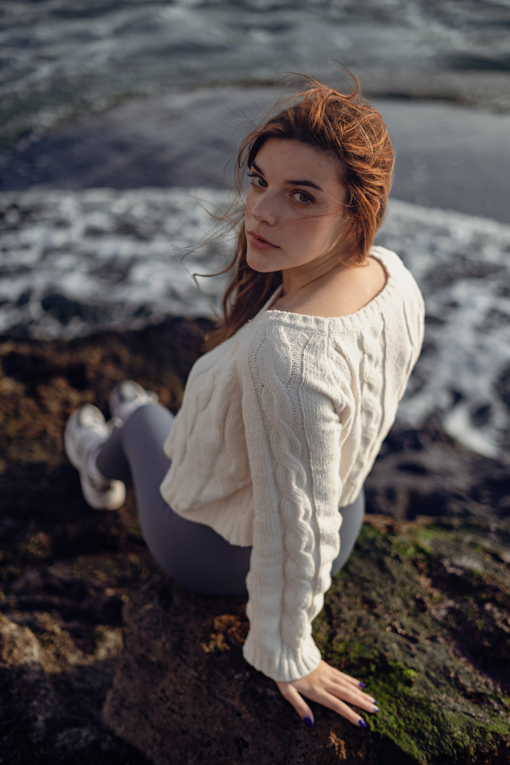 Girl at the cliff looking behind toward the camera