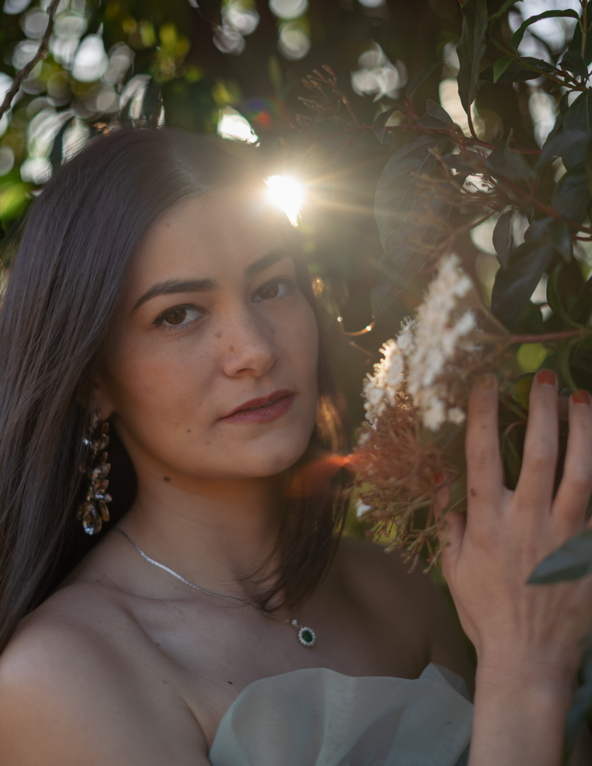 Girl holding flower as sun from behind light the flowers up