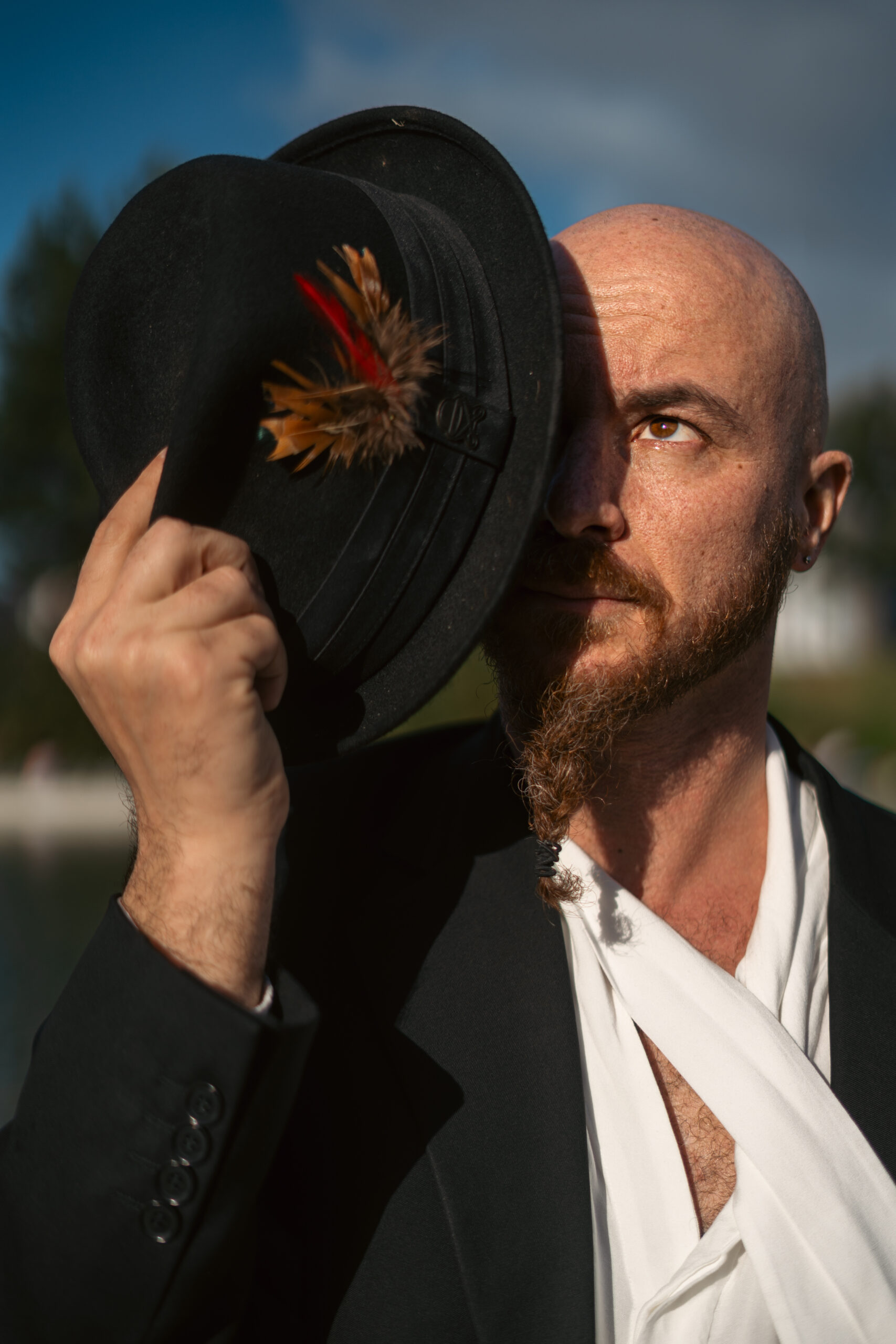 Guy looking at a sun with his hat off
