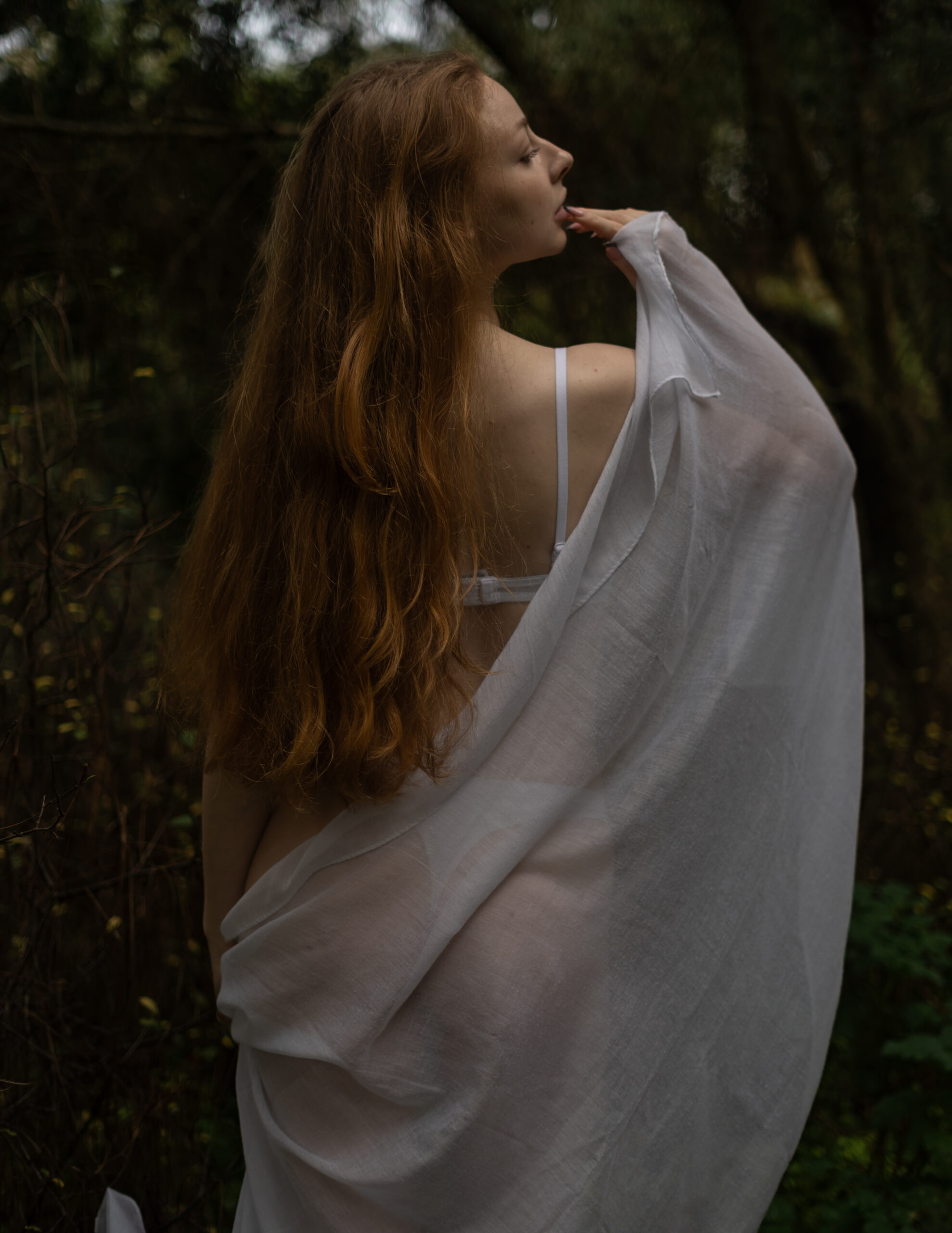 Girl in white linen in middle of forest