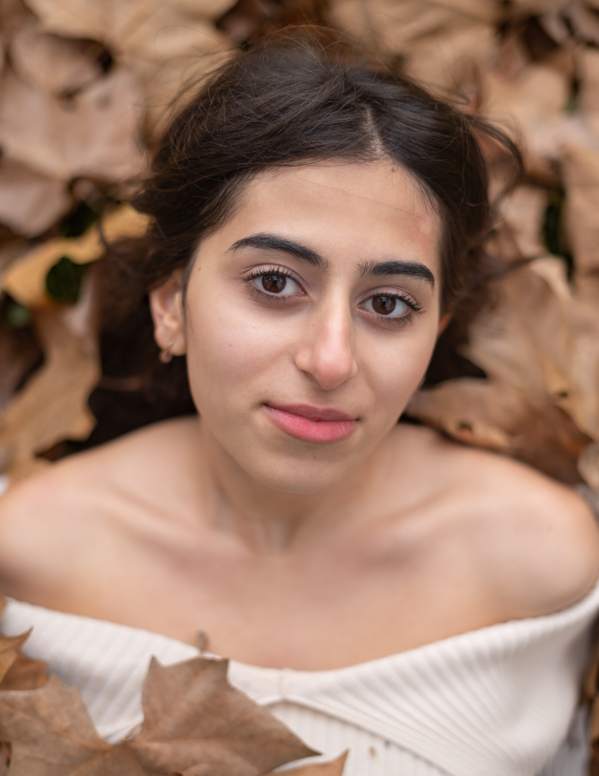 Girl surrounded by fall leaves
