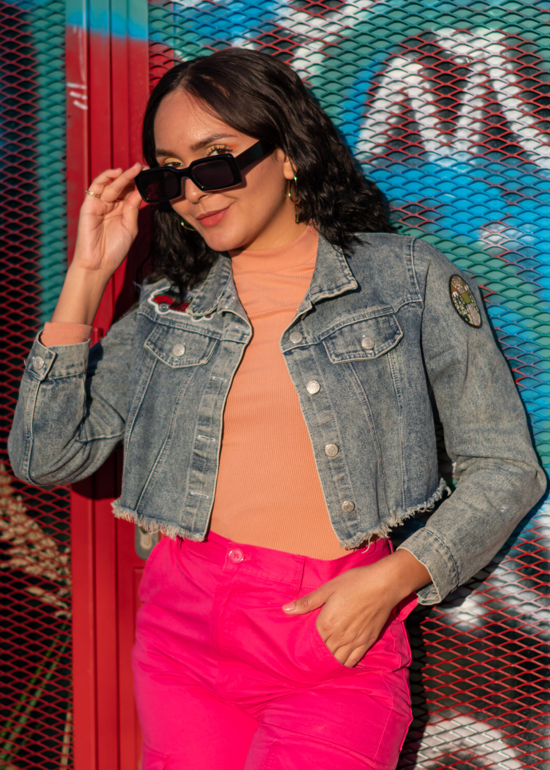 Girl in vibrant outfit in front of a wall